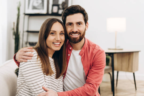istock Happy couple embracing on sofa in living room 2201801759