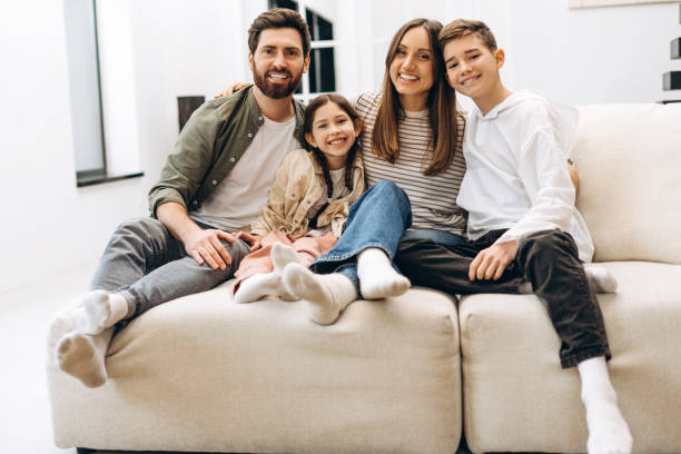 istock Happy family relaxing together on comfortable sofa at home 2201802231
