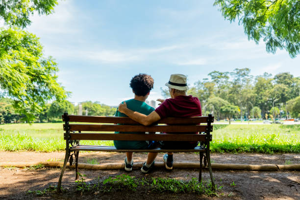 istock Grandfather and grandson talking in a public park 2201802561