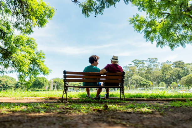 istock Grandfather and grandson talking in a public park 2201802564