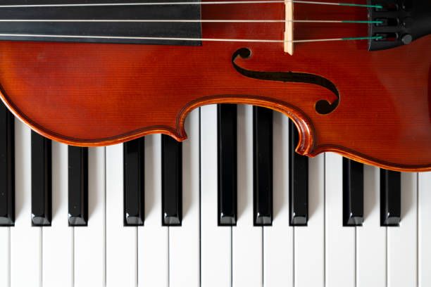 istock Violin on top of piano keyboard background 2201802619