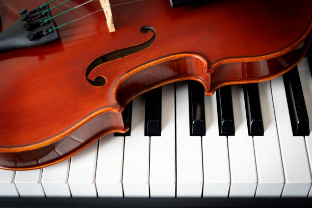 istock Violin on top of piano keyboard background 2201803164