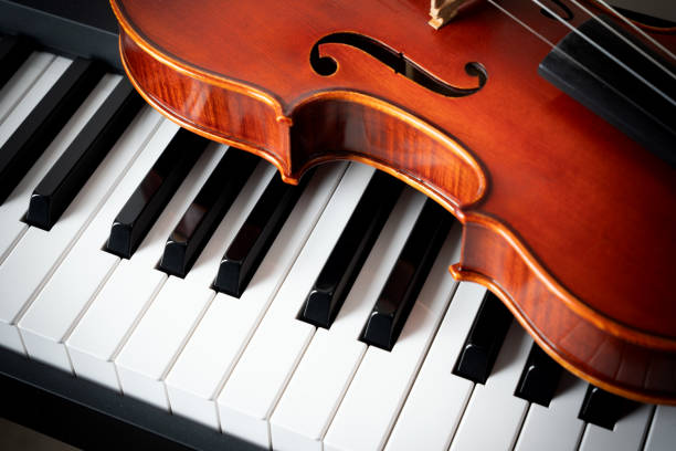 istock Violin on top of piano keyboard background 2201803182