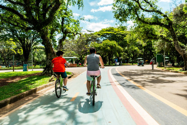 istock Father and son riding bike in a public park 2201803387