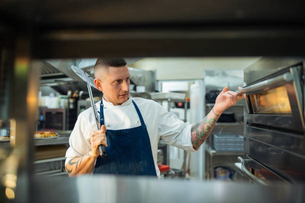 istock Chef baking the pizza in pizza oven. 2201805729