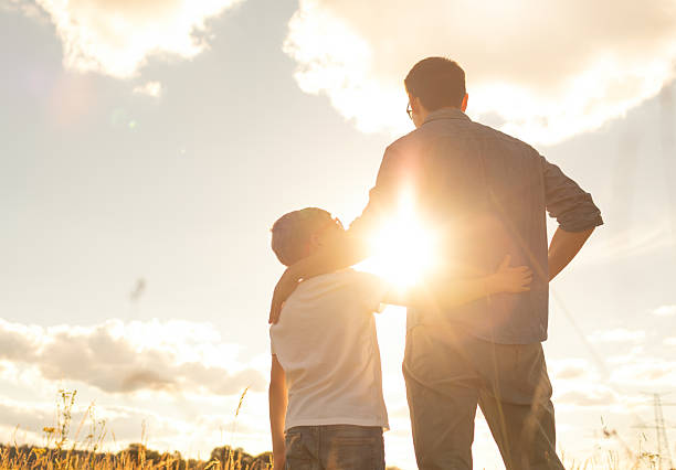 istock Father and child watching the sunset. 2201809040