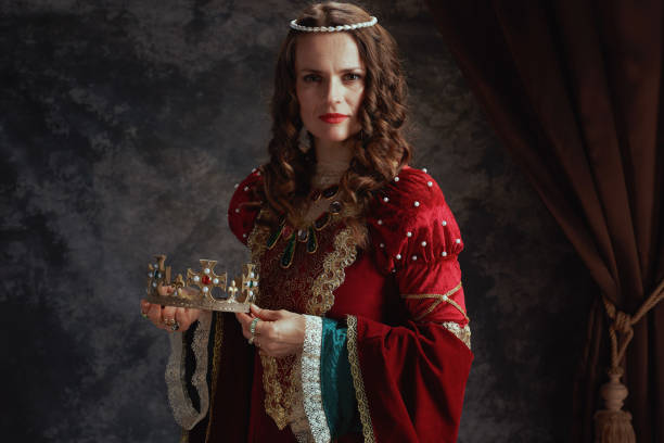 istock medieval queen in red dress with crown 2201813873