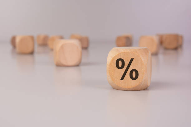 istock wooden block with a percentage symbol on a reflective surface, symbolizing interest rates, and investment 2201815009