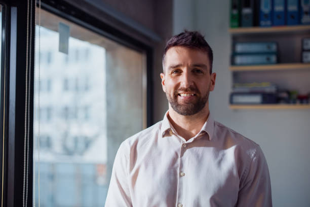 istock Professional Businessman Smiling Indoors in an Office Environment Facing the Window 2201815615