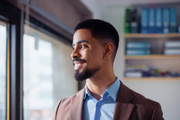 istock Professional Man Smiles Confidently in a Bright Office Environment 2201815656