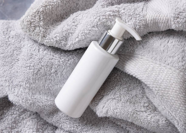 istock White blank one pump cream bottle on light grey bath towel top view, cosmetic mockup 2201816337