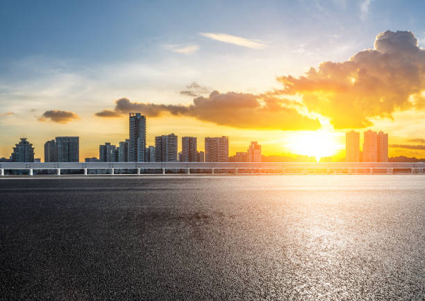istock Asphalt road with modern city buildings scenery at sunrise 2201821005