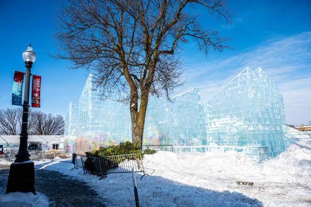 Facade of Bonhomme Carnaval Ice Palace during winter day with a tree and Carnaval sign on a street lamp post