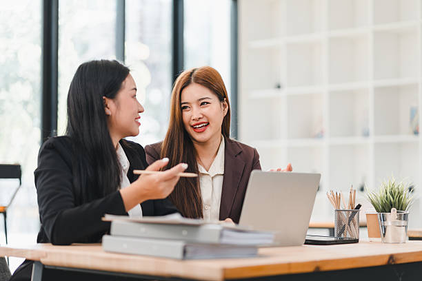istock Two businesswomen discussing work with laptop in office 2201826625