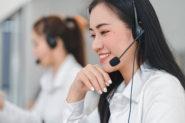 istock Smiling female call center agent wearing headset at work 2201826659