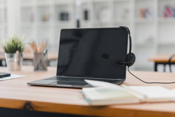 istock Laptop with headset on wooden desk in modern office workspace 2201826707