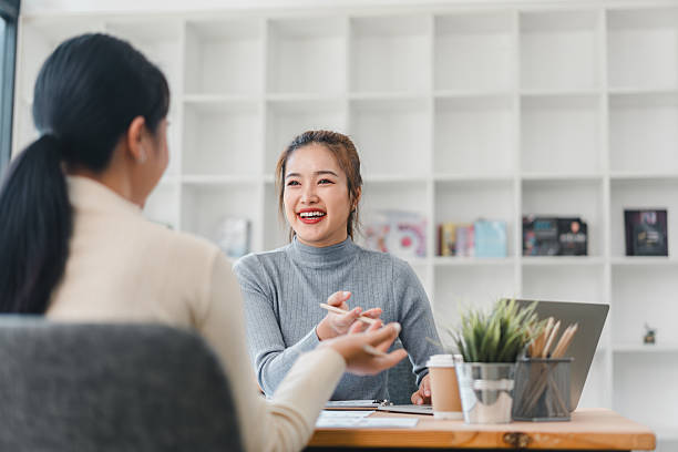 istock Two women discussing work in modern office with laptop 2201827536