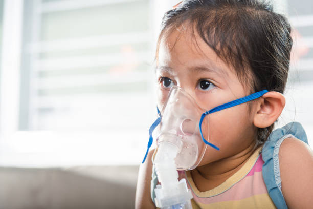 istock Asian Child using nebulizer mask equipment alone have smoke 2201828098