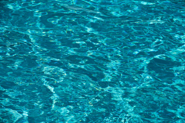 surface of blue swimming pool,background of water in swimming pool. Ripple Water in swimming pool with sun reflection