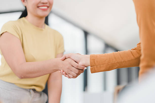 istock close up of two people shaking hands with smiles 2201828374