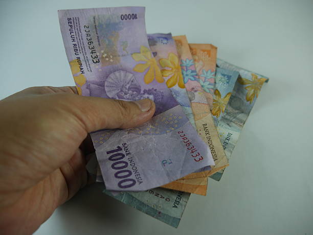 istock hand holding a sheet of rupiah money 2201830163