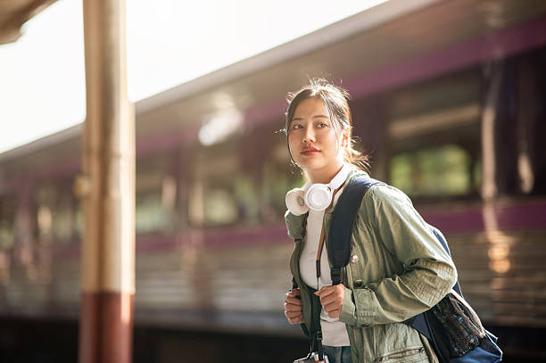 istock An asian woman is looking ahead while holding her bag straps, walking through the train station. 2201836932