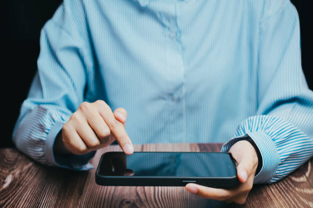 istock Young Person Using Smartphone Touchscreen with Finger on Table, Business concept 2201837943