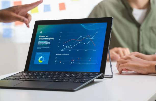 istock laptop when present  business presentation in a dimly lit office, analyzing financial charts and data projections on a screen 2201838326