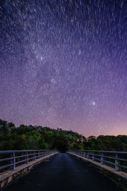istock Star filled night sky above a long narrow bridge 2201838766