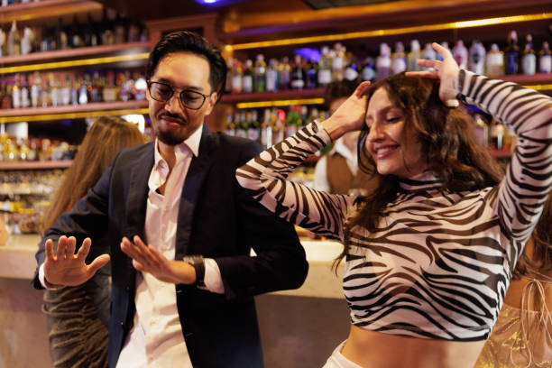 istock Diverse happy friends with drinks dancing at bar counter 2201845285