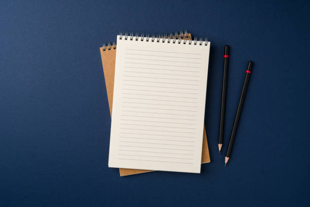istock Top view of notebook and pencil on blue background 2201845553