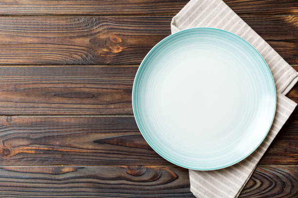 istock Top view on colored background empty round blue plate on tablecloth for food. Empty dish on napkin with space for your design 2201849797