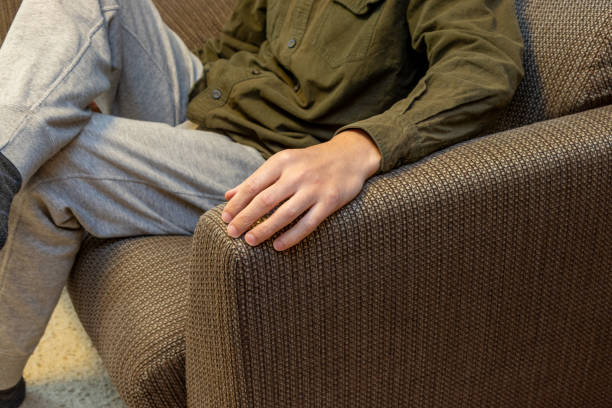 istock A man sitting on a sofa with his arm resting on the armrest 2201850326