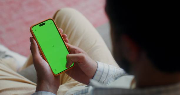 istock A phone with a green screen in men's hands 2201850371