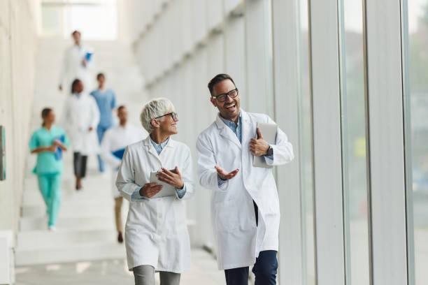 istock Happy doctors talking while walking through hallway of a hospital. 2201850439