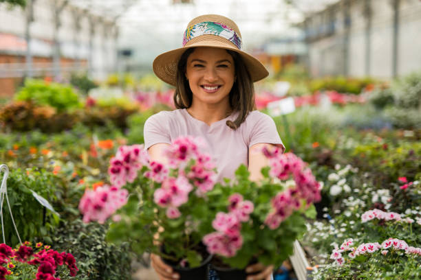 istock Happy young woman at flower center 2201851781