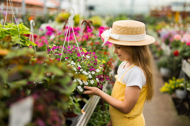 istock Little girl exploring at flower center 2201851872