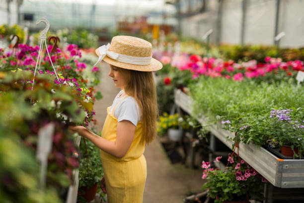 istock Little girl exploring at flower center 2201852102