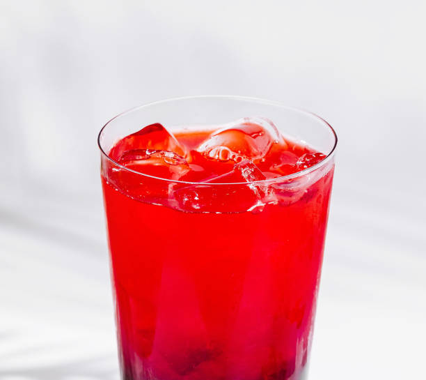 istock Glass of red cocktail with ice cubes on white background 2201854264