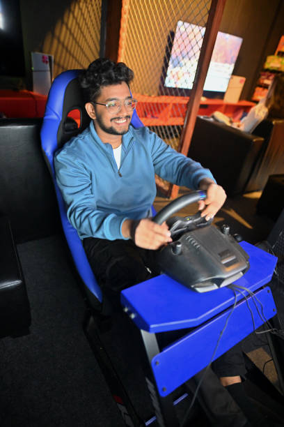 istock Young cheerful man enjoying a car racing game in a gaming hub 2201856808