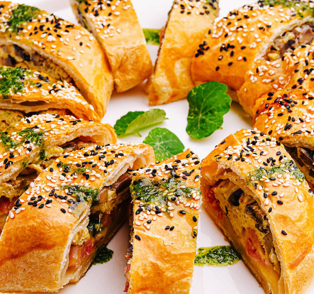 istock Freshly baked savory rolls arranged beautifully on a white platter with sesame seeds and herbs 2201856965