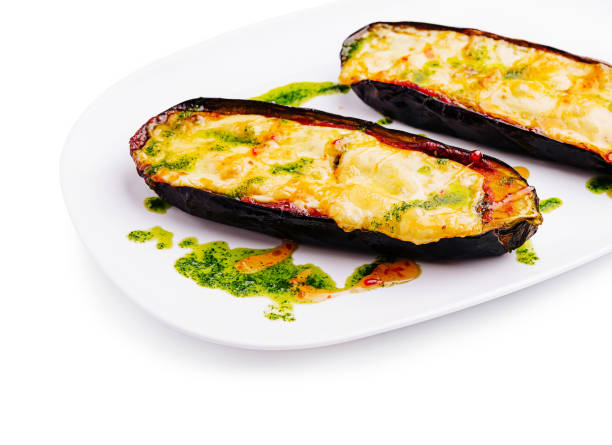 istock Savory stuffed eggplants with cheese and green sauce served on a white plate 2201857039