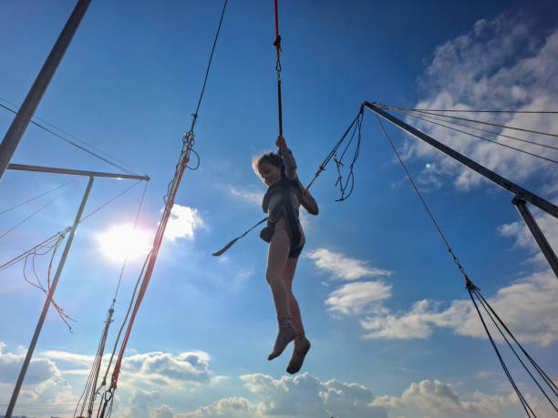 Trapeze artist swinging in the blue sky