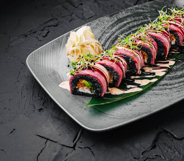 istock Delicious sushi roll presented elegantly on a dark plate with wasabi and pickled ginger 2201858114