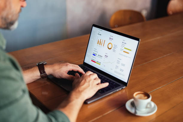 istock Man Working on Laptop Analyzing Business Data at a Coffee Shop 2201858176
