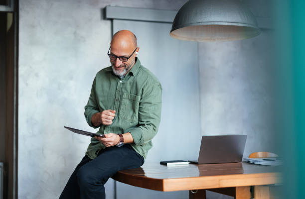 istock Man Working in Modern Office Holding Tablet by Desk 2201858291