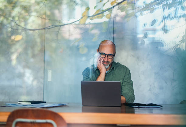 Businessman Working on Laptop in a Modern, Well-Lit Office Environment