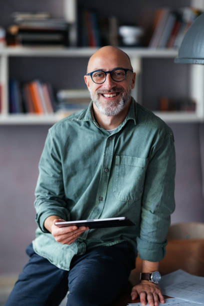 istock Smiling Business Professional Holding Digital Tablet in Modern Office Setting 2201858311