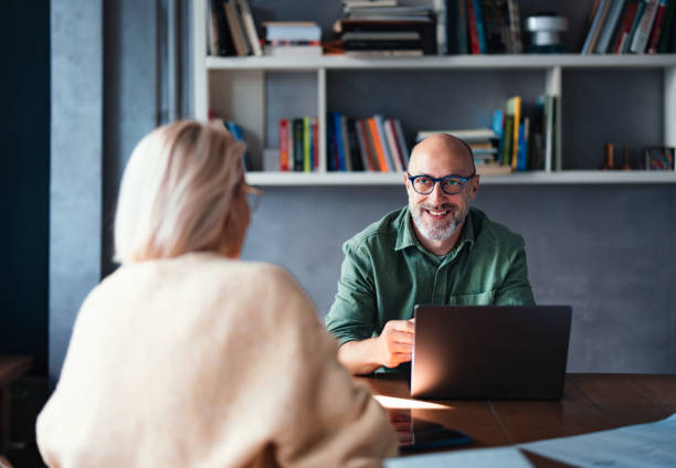 istock Man Engaging in Professional Discussion at Library Workspace with Laptop 2201858314