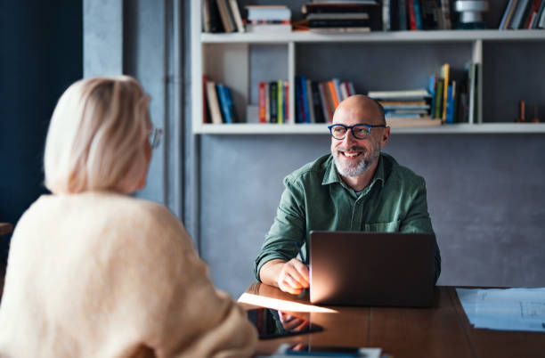 istock Friendly Business Interaction Between a Professional and Colleague in a Shared Workspace 2201858318